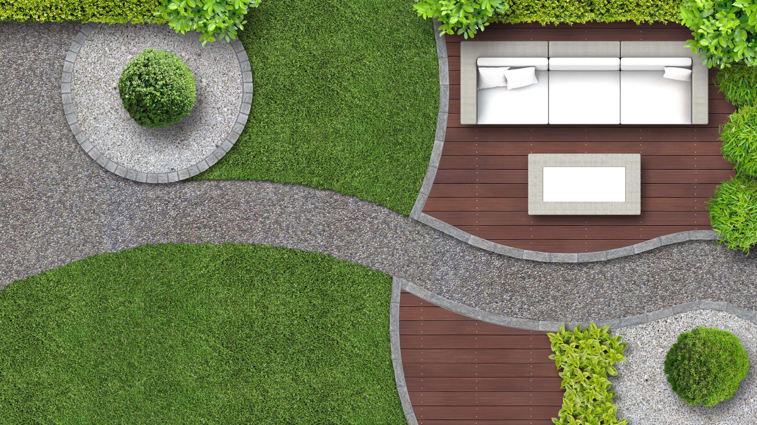 Top view of landscaped yard with curved gravel pathway, round shrubs, wooden deck, and white outdoor sofa surrounded by greenery.